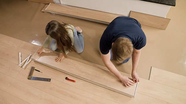 Eine Tochter verlegt mit ihrem Vatereinen Ceramin Bodenbelag